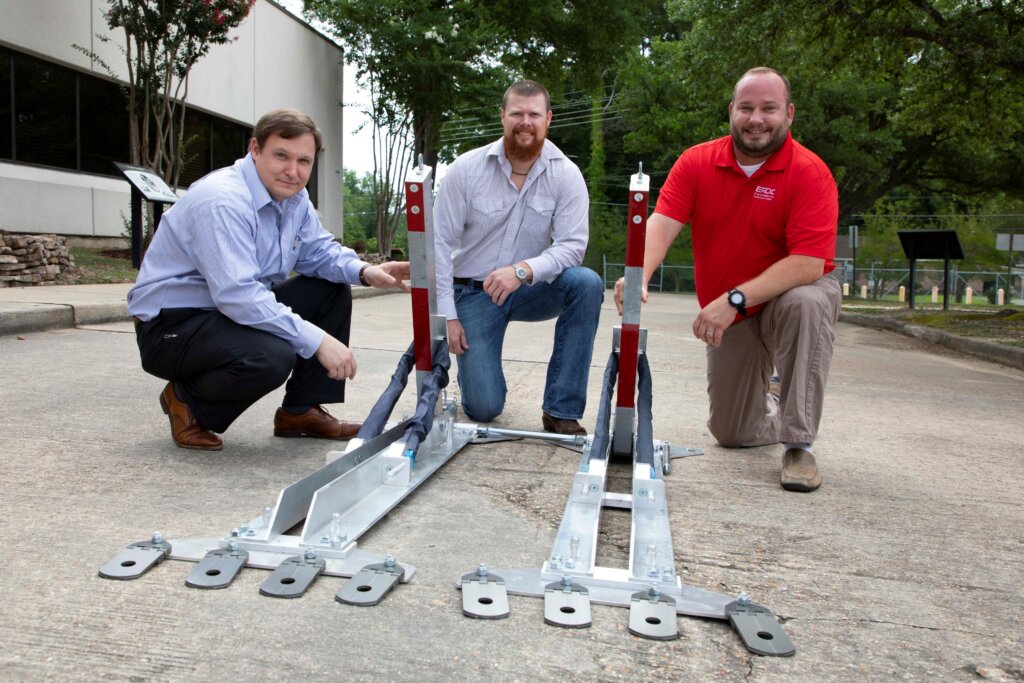 Justin Roberts (center) poses in front of the Aggressor Vehicle Entry Readiness Technology (AVERT) with co-inventors Christopher Price (left) and Josh McCleave (right)