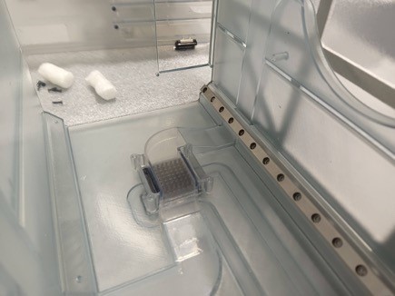 Transparent walls house a small square heat exchanger.