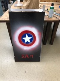 Modular ladder and protection system panel mounted on a metal frame in a workshop with a white star in a blue, red, and white circles.