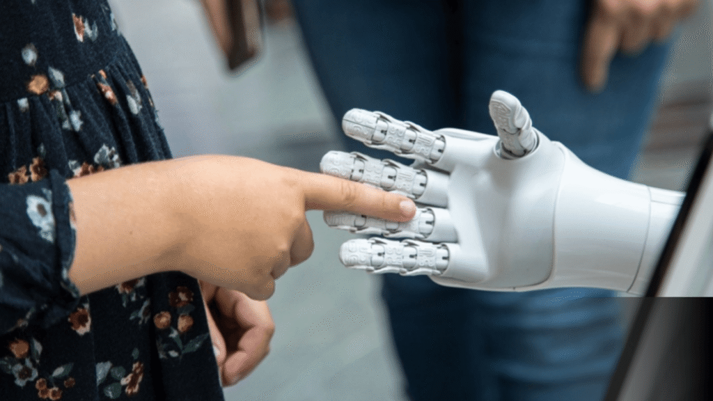 A human hand touches a white, robotic hand.