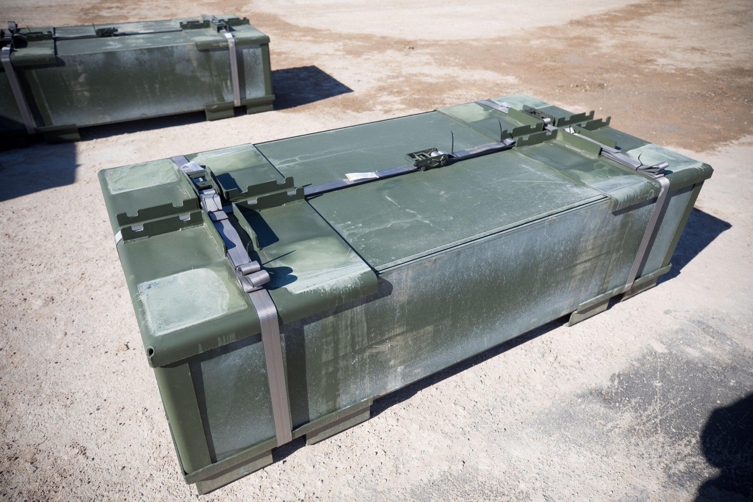 Rectangular cubic bundle of AML panels held together with ratchet straps.