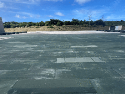 Rectangular green AML panels assembled in a large array over an asphalt concrete surface